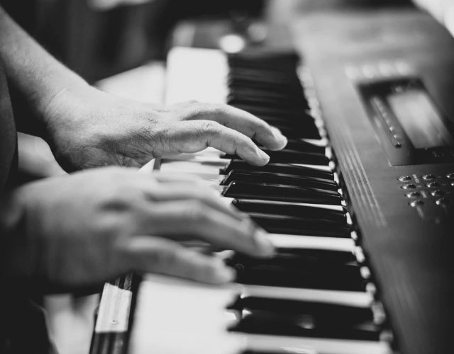 Black and white image of person playing piano