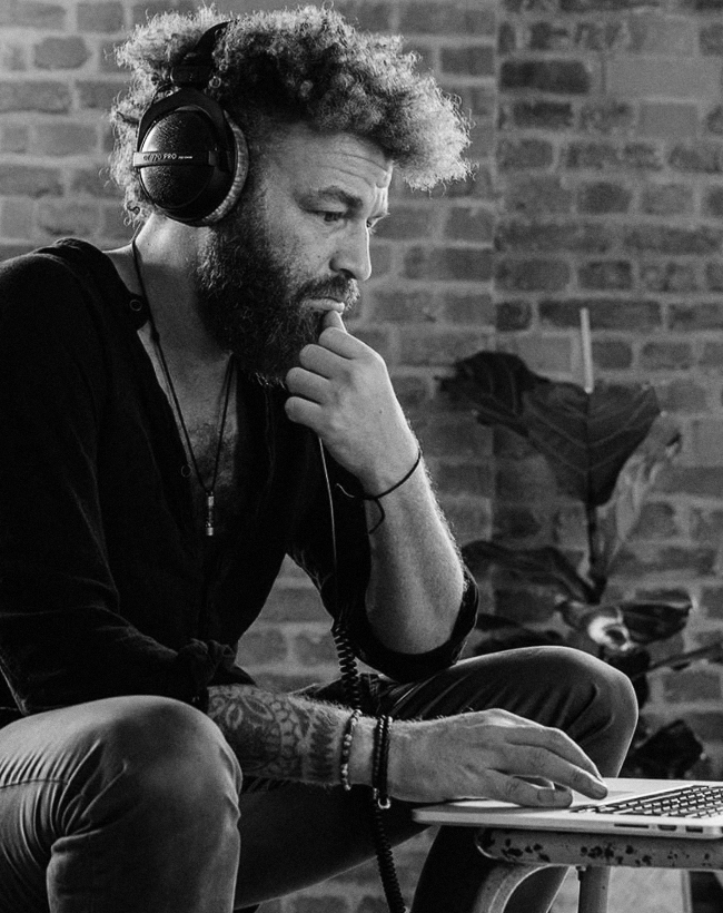 Man on computer wearing Beyerdynamic DT770 PRO headphones
