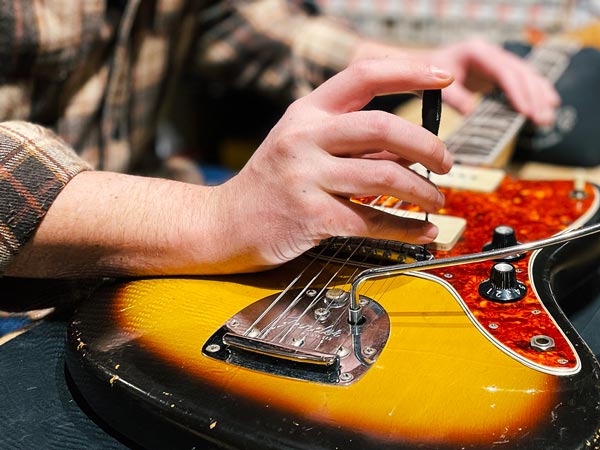 Red Gibson electric guitar lying face up on workbench with tools