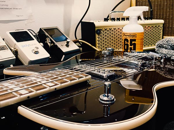 Red Gibson electric guitar lying face up on workbench with tools