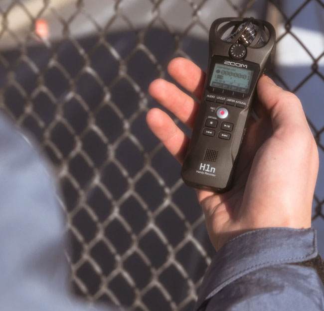 Person recording audio outside with a Zoom recorder