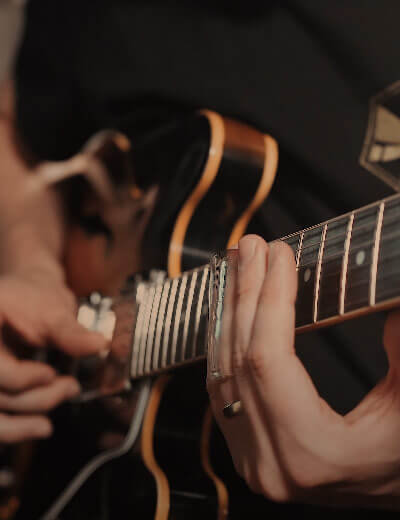 close up of man playing slide guitar